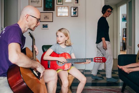 Entspannte Elternrolle: Vater gibt Tochter Gitarrenunterricht
