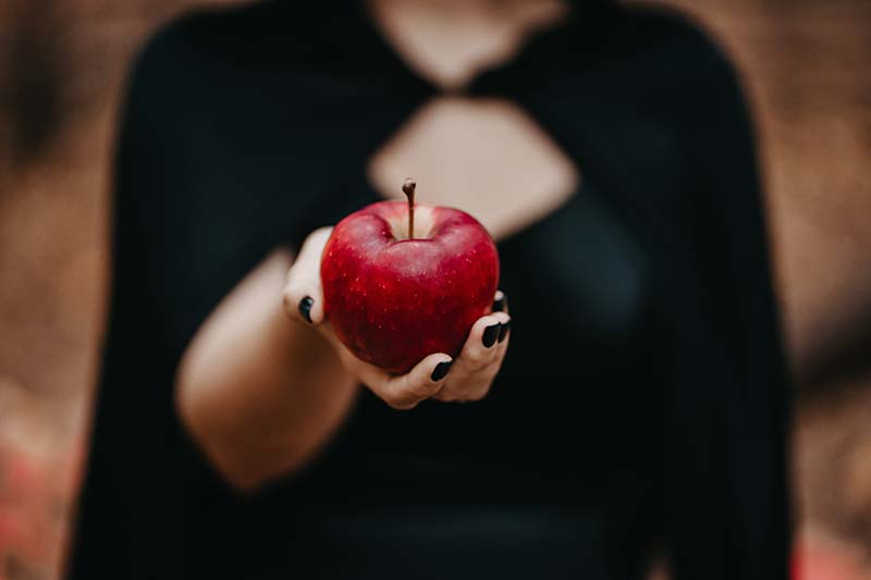 Das Urbild für toxische Weiblichkeit: Eine Frau reicht einen Apfel