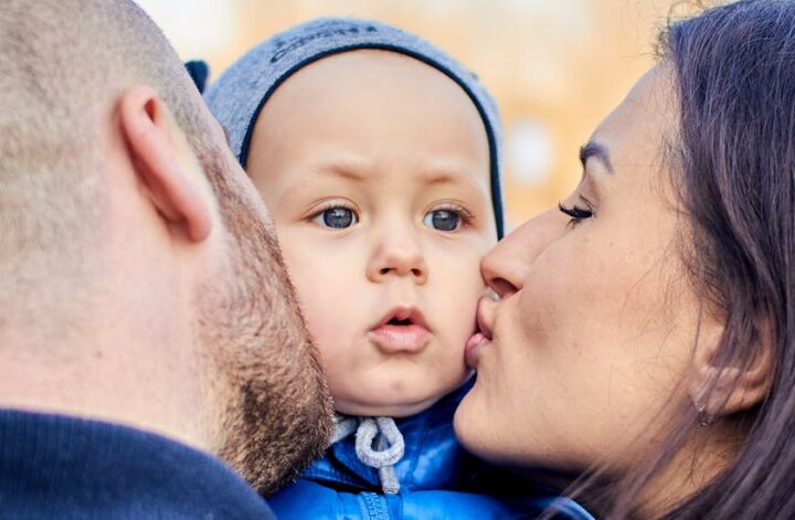 FAMILIENKONGRESS Hannover 2024: Symbolbild. Vater und Mutter küssen ihr Baby