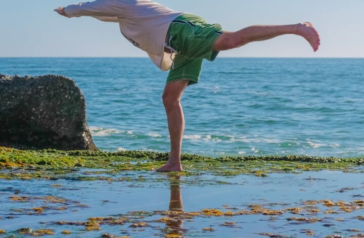 Männergesundheit: Ein Mann am Meer macht eine Streckübung